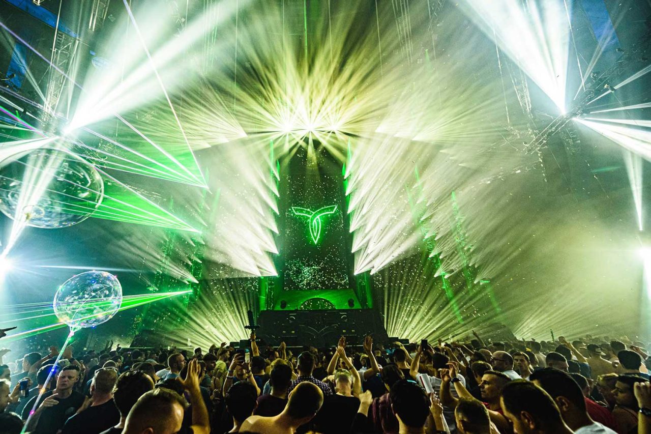 Dense green and white laser effects above the Transmission Festival audience.