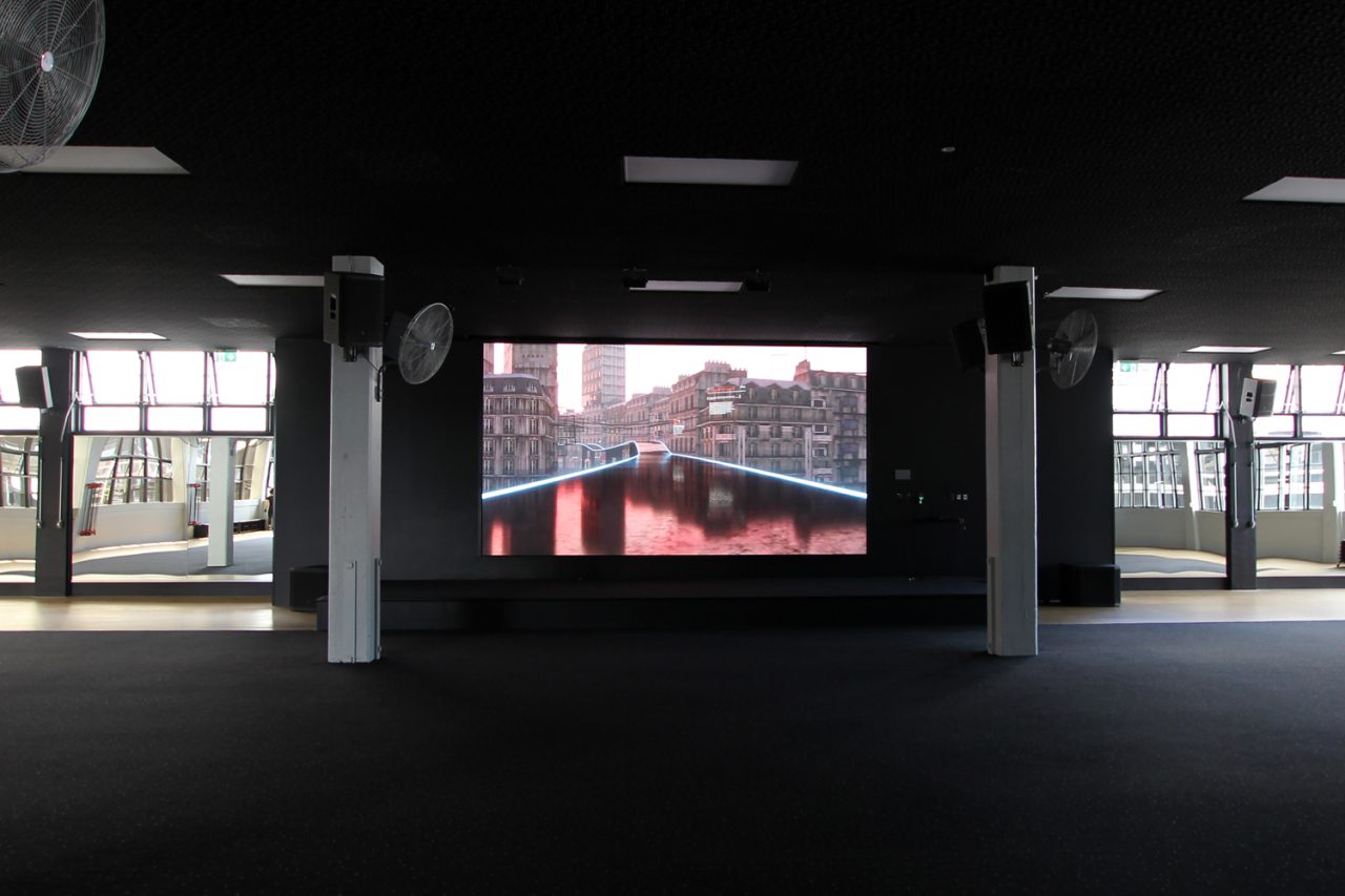 Red-toned video imagery on the studio screen at Les Mills Auckland City.