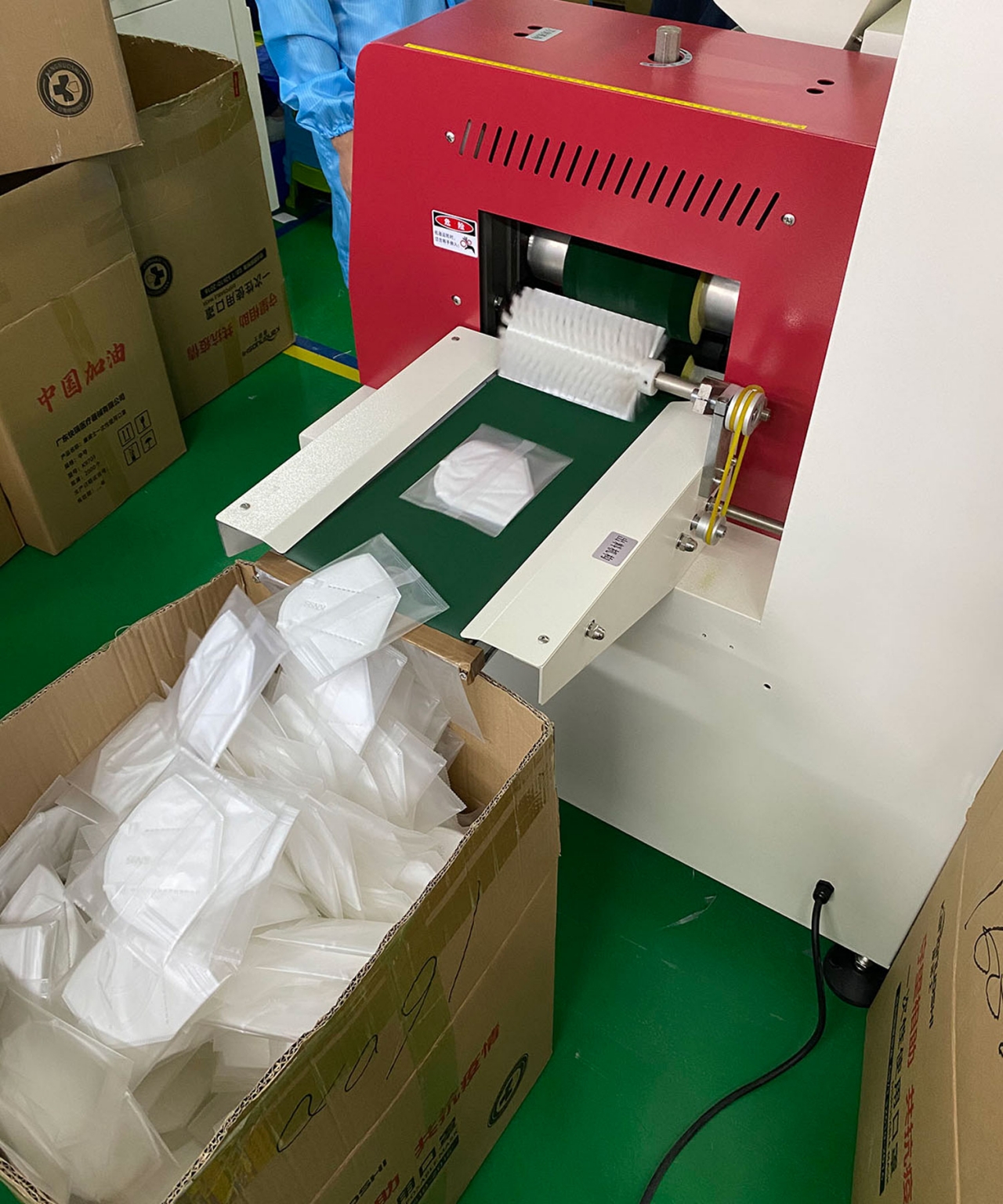 Face masks emerging from a production machine at Astera's factory.
