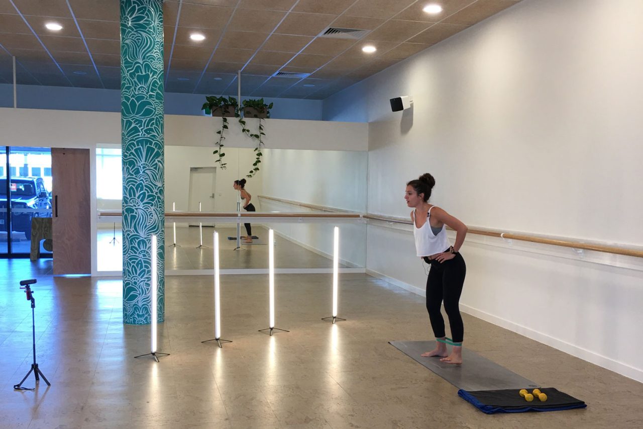 Instructor and upright tube lights arranged for streaming in the Floating Lotus studio.