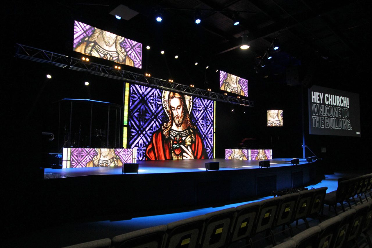 Video imagery across the stage screens and overhead ribbon at Glow Church.