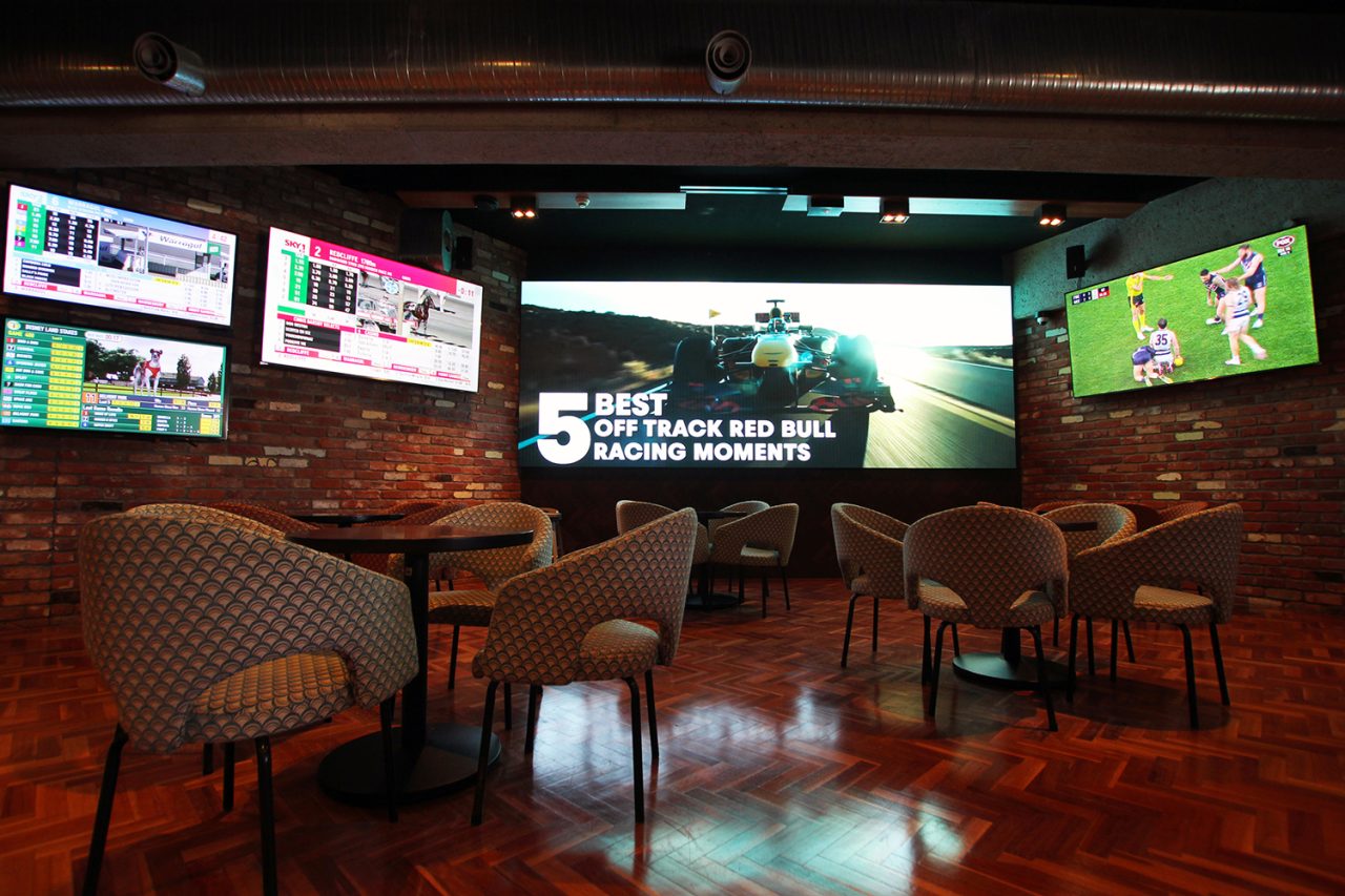 Large central display flanked by sports broadcasts at 1st on Wharf Tavern.