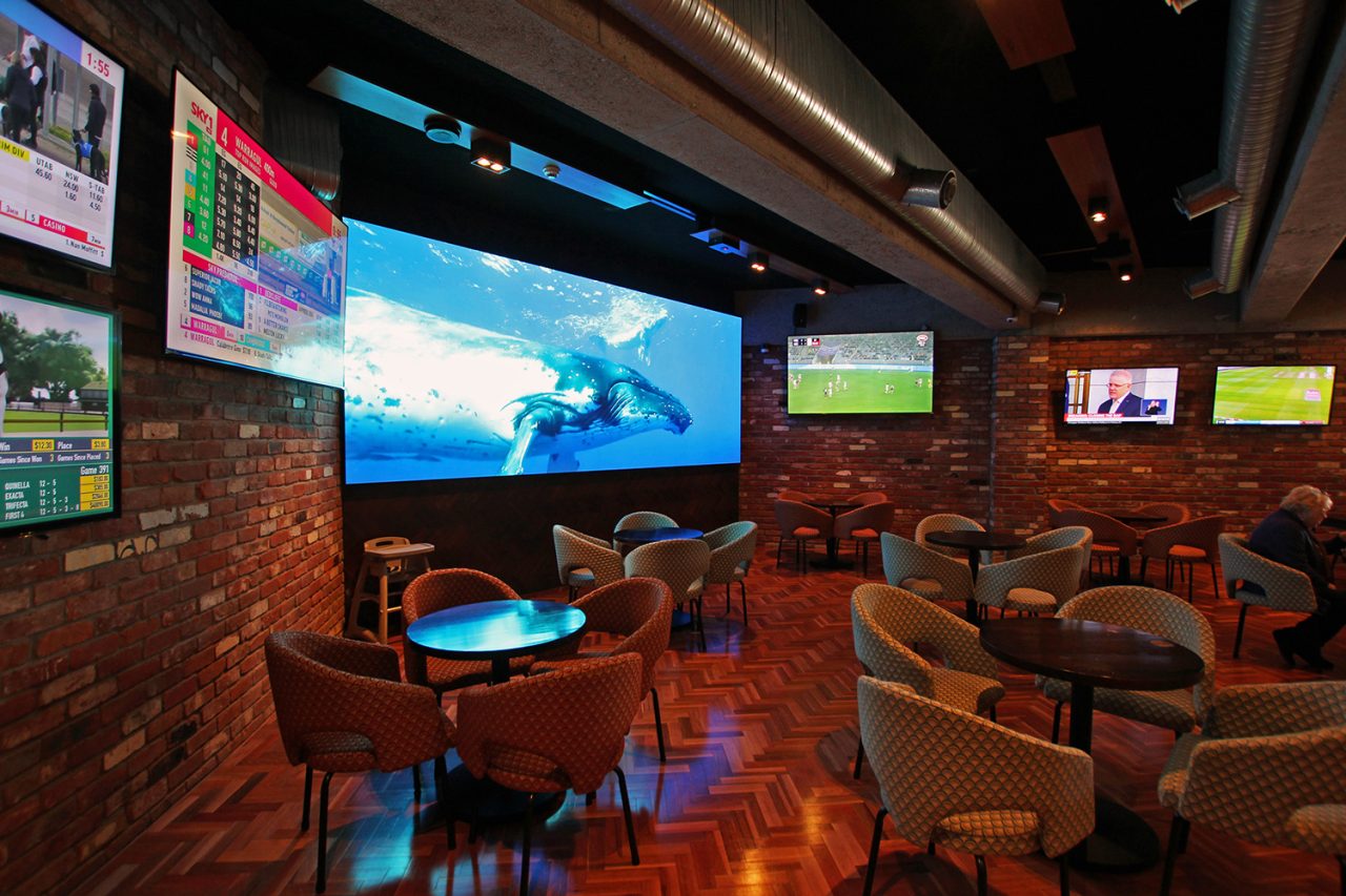 Wide display showing blue ocean imagery in the 1st on Wharf Tavern lounge.