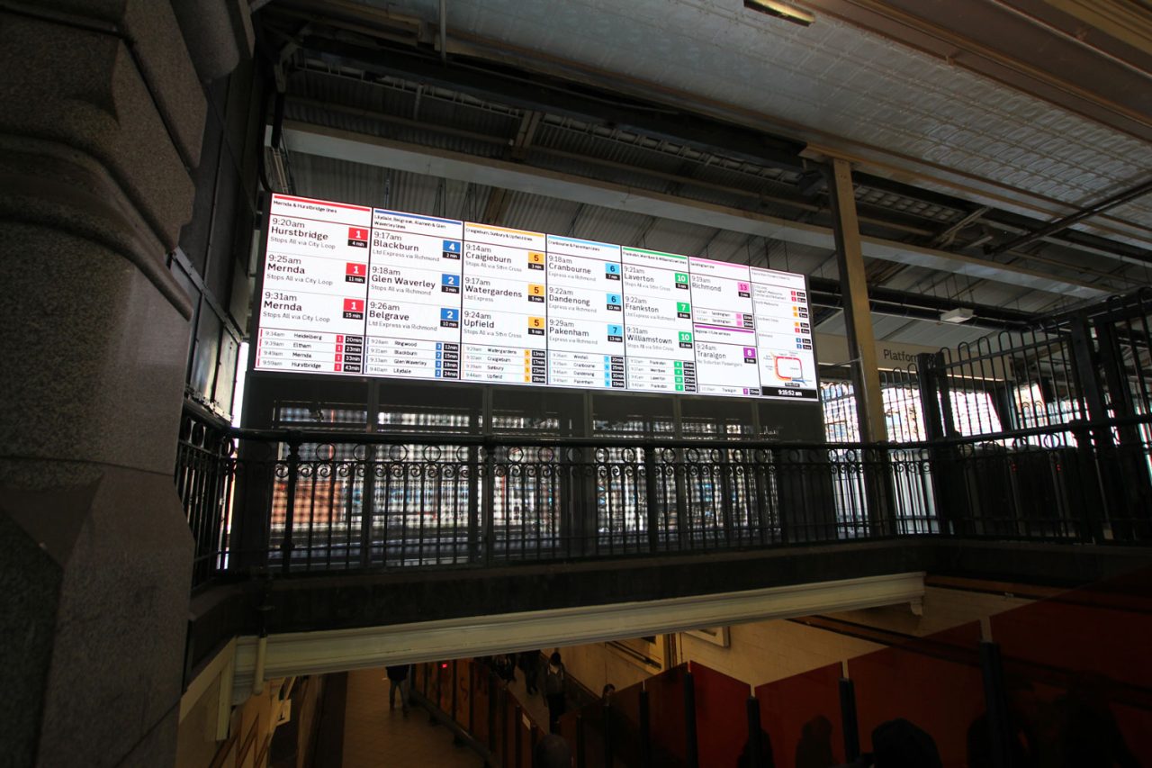 View from a stairway towards the electronic departure board at Flinders Street Station.