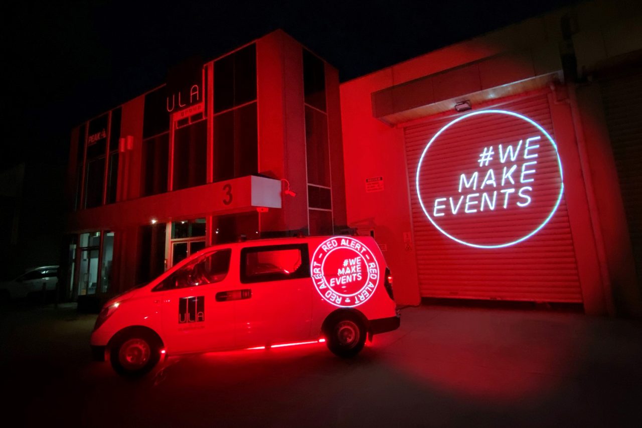 ULA's Melbourne office and vehicle lit red with a We Make Events projection.