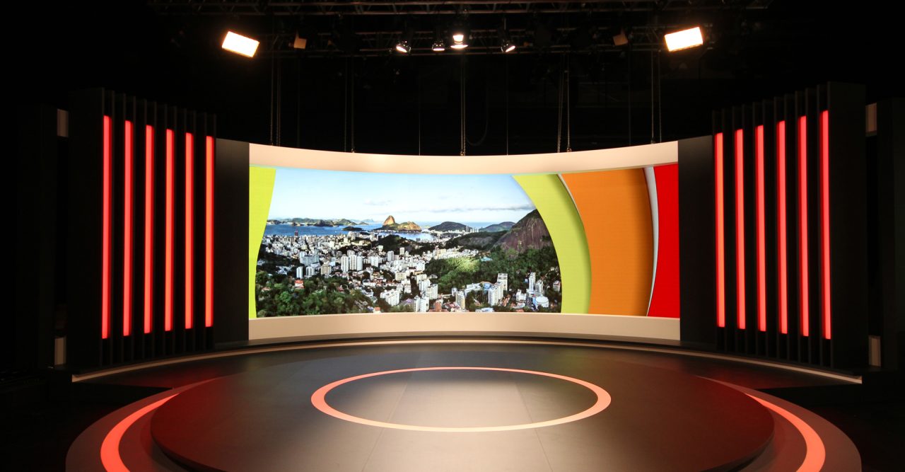 Curved LED backdrop behind a circular stage in a television studio.