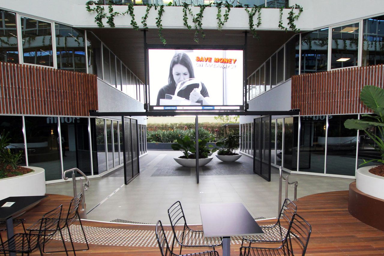 Suspended LED screen showing advertising above the seating at 339 Coronation Drive, Milton.