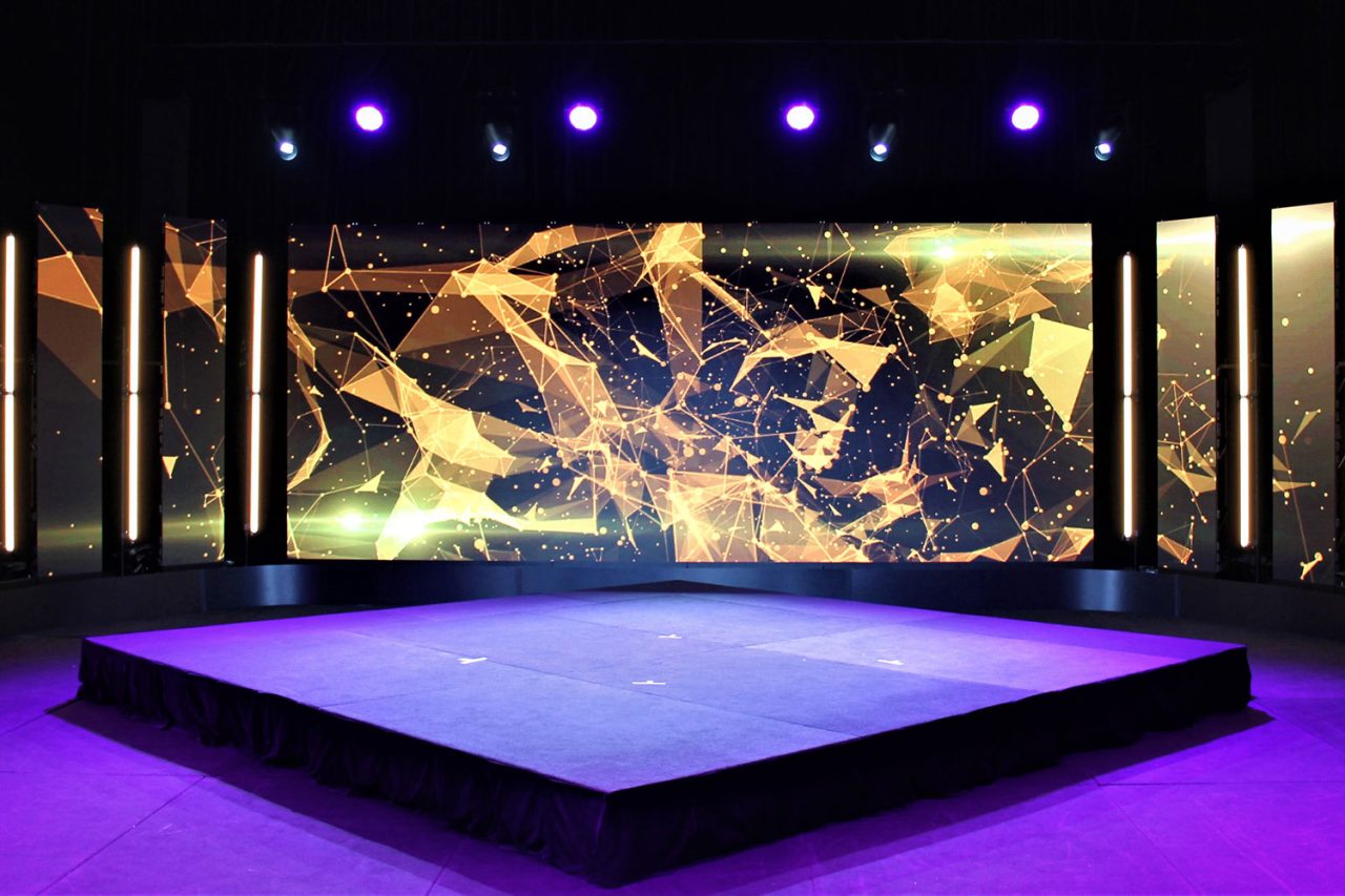Empty Scene Change virtual-studio stage lit purple beneath a gold abstract digital backdrop.