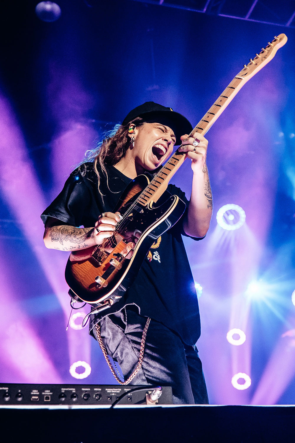 Tash Sultana playing guitar under purple lighting at Great Southern Nights.
