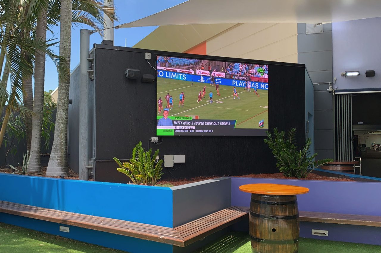 Large outdoor screen showing a rugby broadcast at Redcliffe Leagues Club.