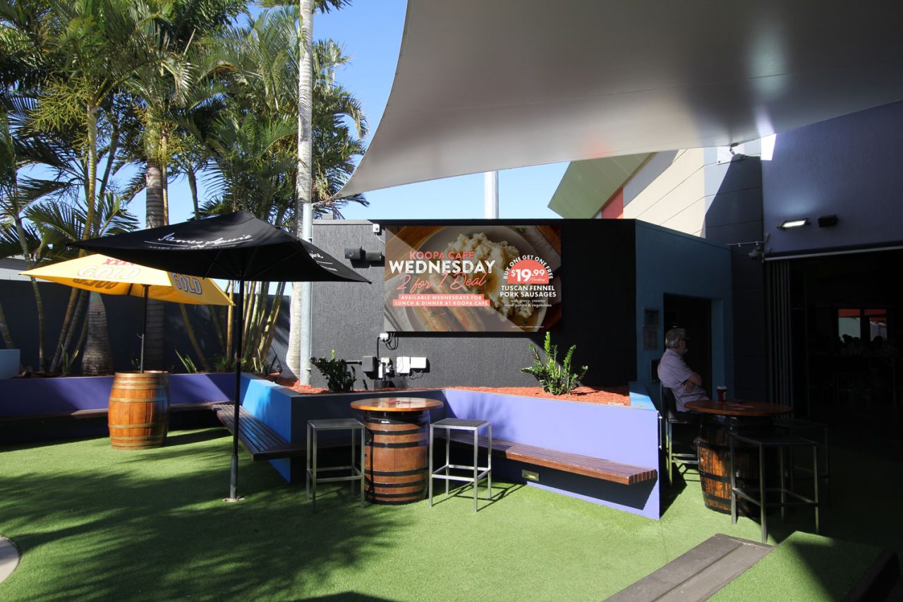 Outdoor seating and screen beneath shade sails at Redcliffe Leagues Club.