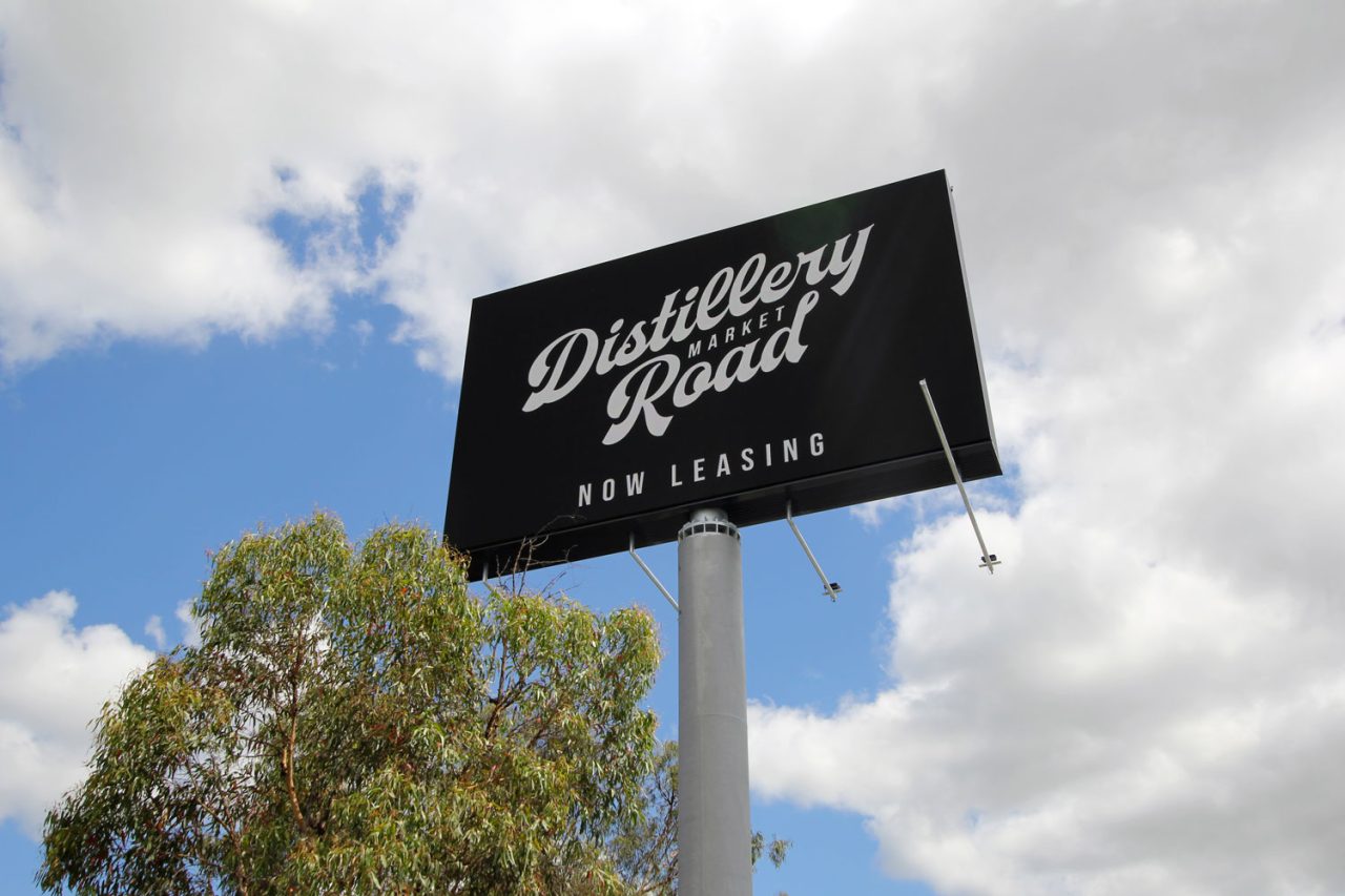 Roadside digital billboard at Zarraffa’s Eagleby headquarters displaying Distillery Road Market branding.