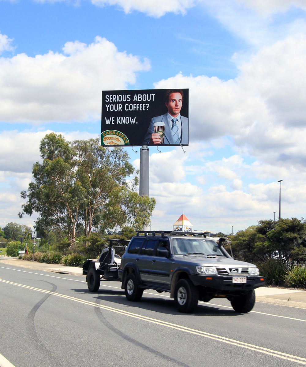 Traffic passing the elevated digital billboard at Zarraffa’s Eagleby headquarters.