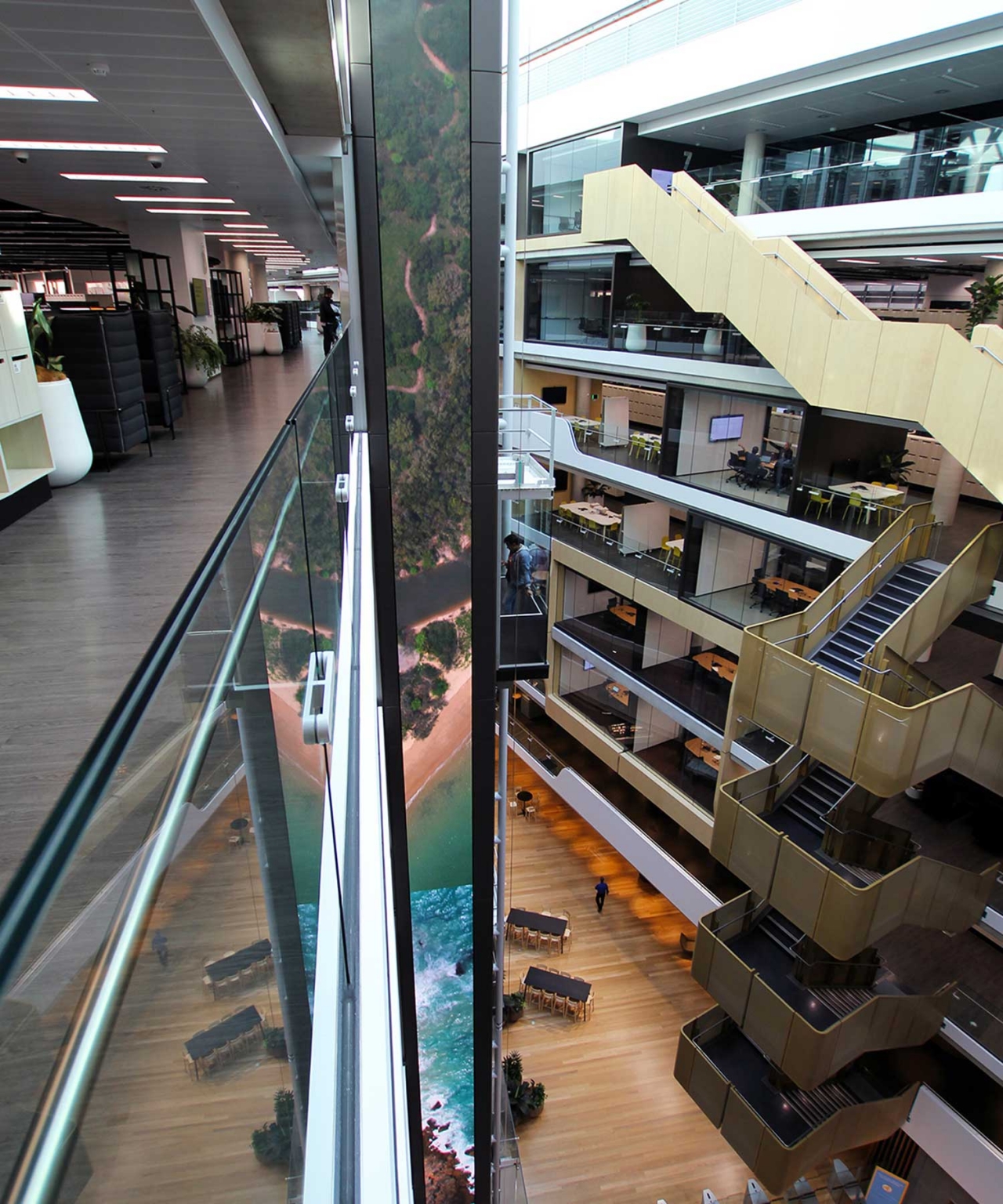 View along an upper-level balcony towards the tall digital column in the headquarters atrium.