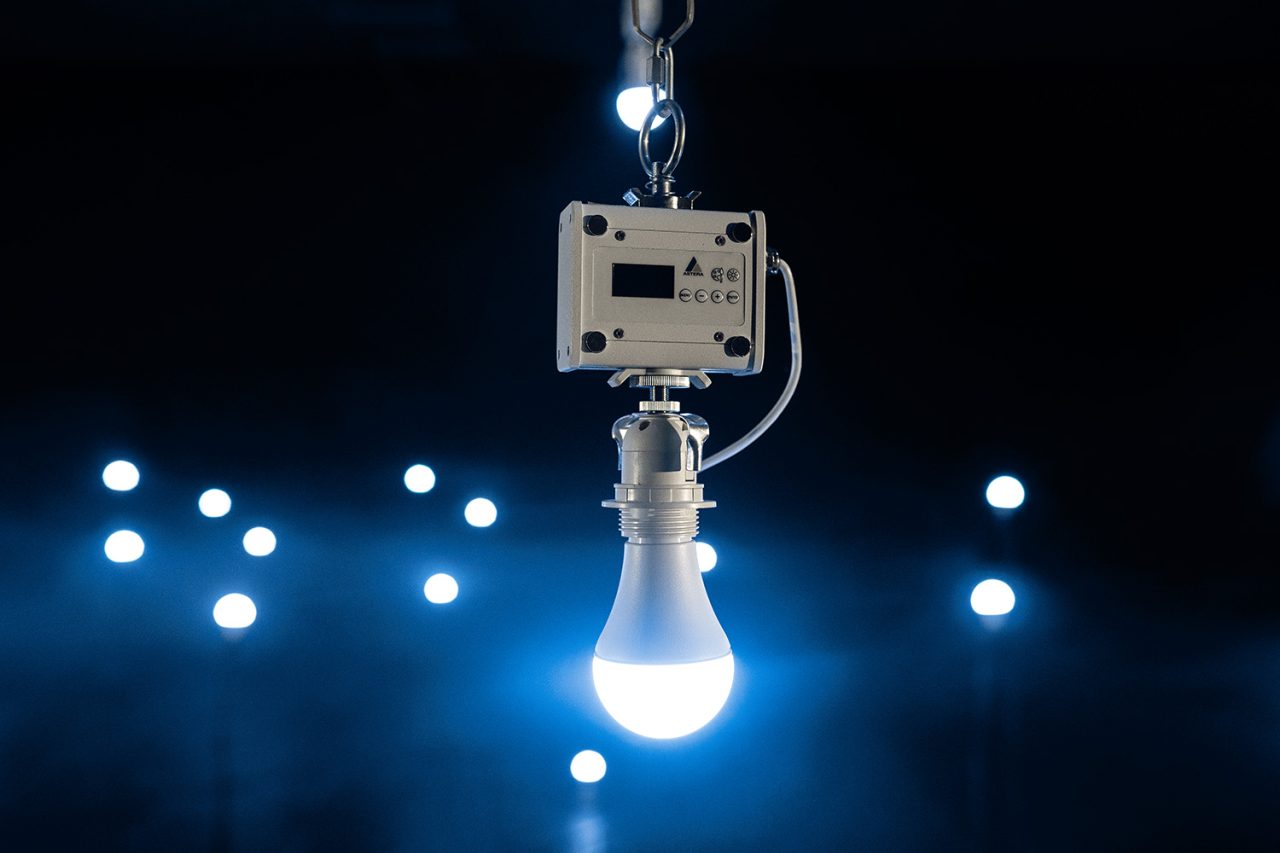 An illuminated Astera NYX Bulb suspended beneath a control unit.