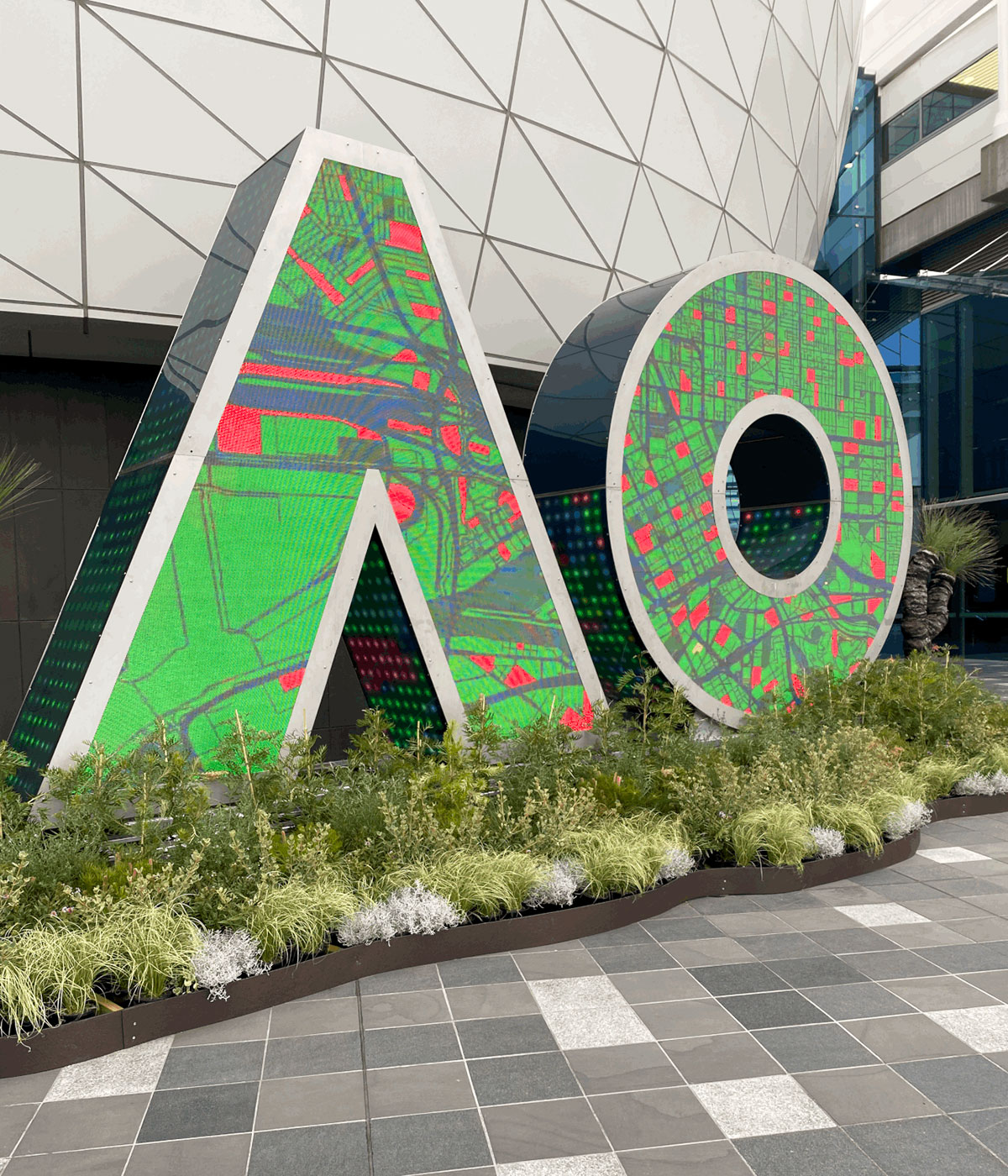 AO digital letter sculpture showing green imagery outside the Australian Open venue.