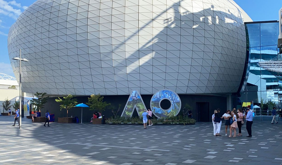 Wide view of the Australian Open venue exterior with the AO digital sign and visitors.