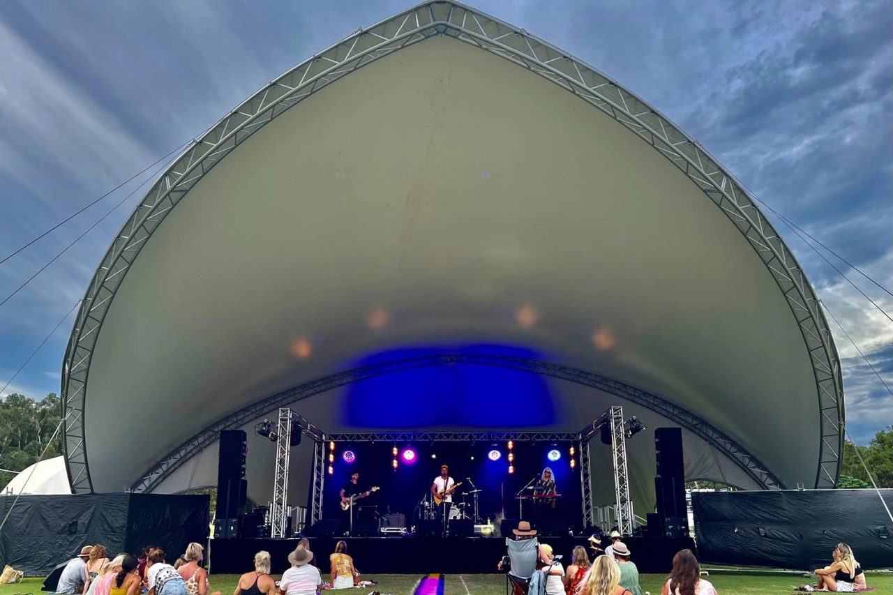 Performers beneath the curved outdoor canopy at SummerStage Byron Bay.