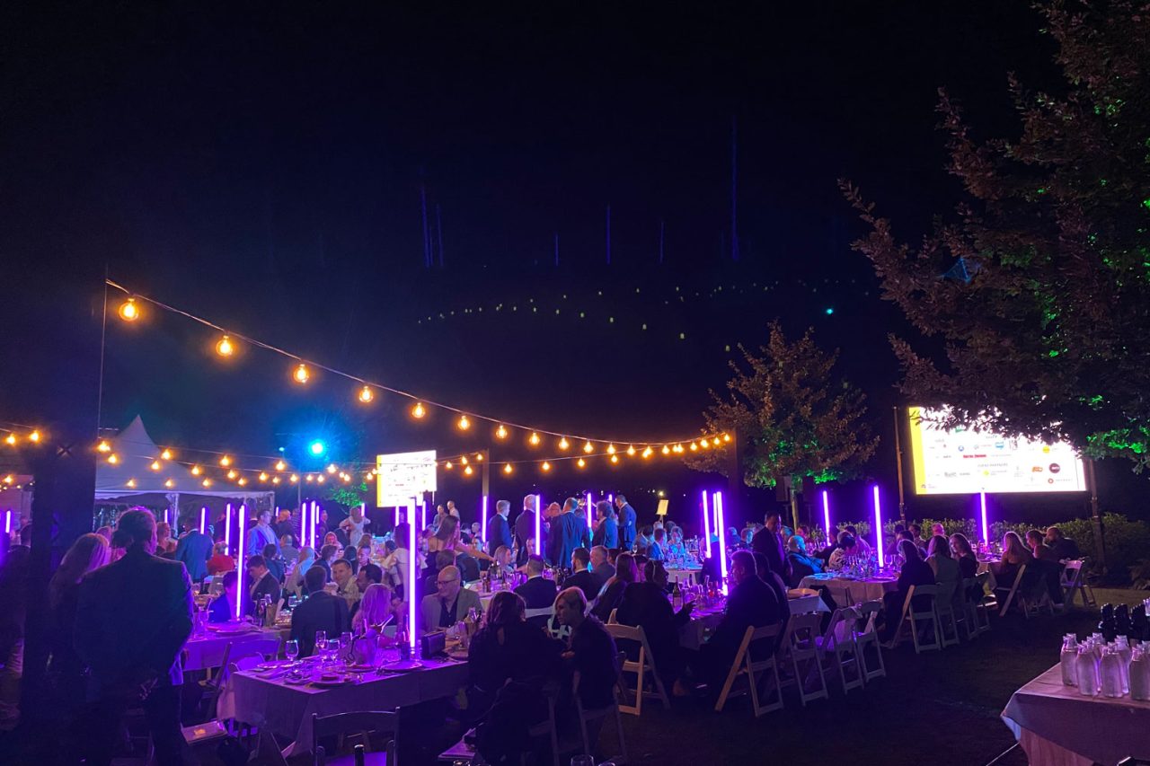 Wide view of the AHA Awards dinner in Canberra beneath string lights and purple light tubes.