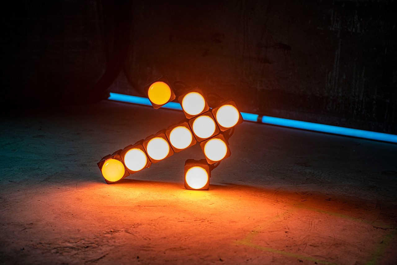 Amber-lit Astera PixelBricks arranged in an arrow shape.