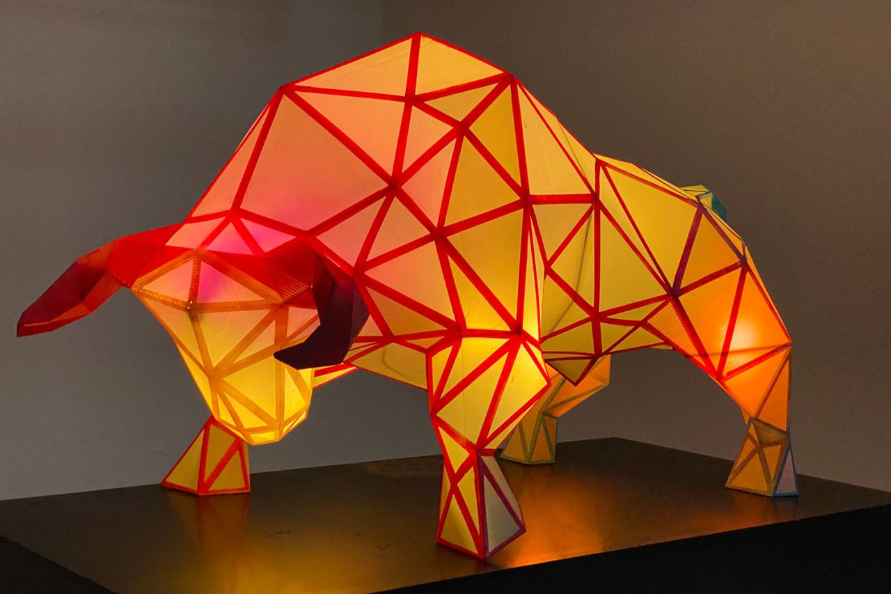 The illuminated ox sculpture in Darling Harbour with yellow, orange and red panels.