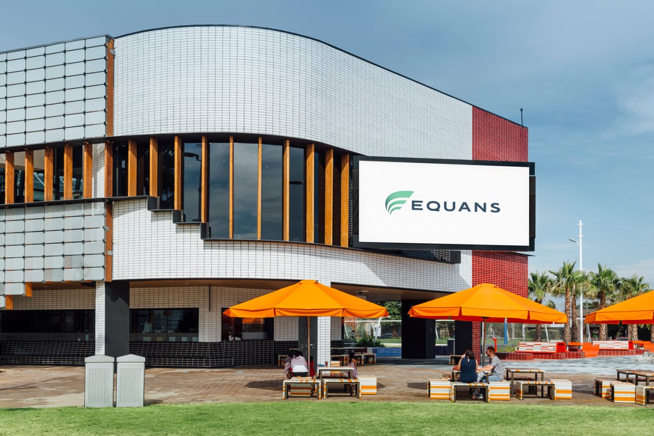EQUANS branding on the Springvale Urban Screen above orange umbrellas.