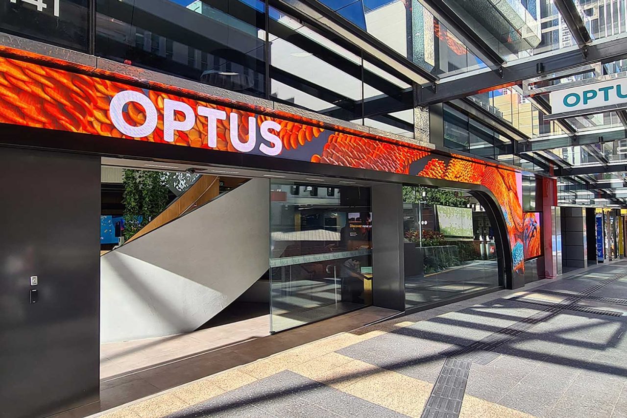 Close view of the Optus entrance with a red and orange LED display above the doors.