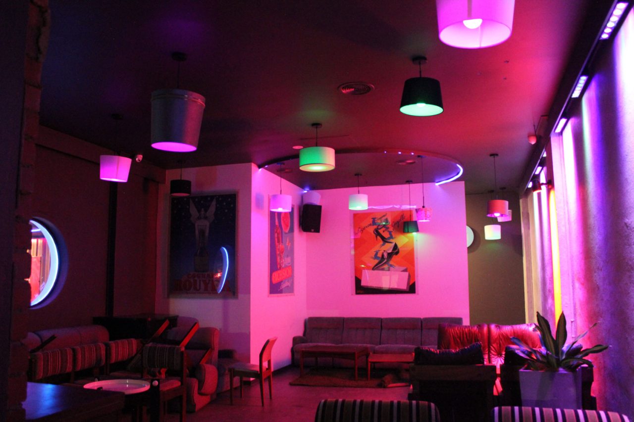 Lounge seating and columns illuminated pink and purple at One22 bar in Canberra.