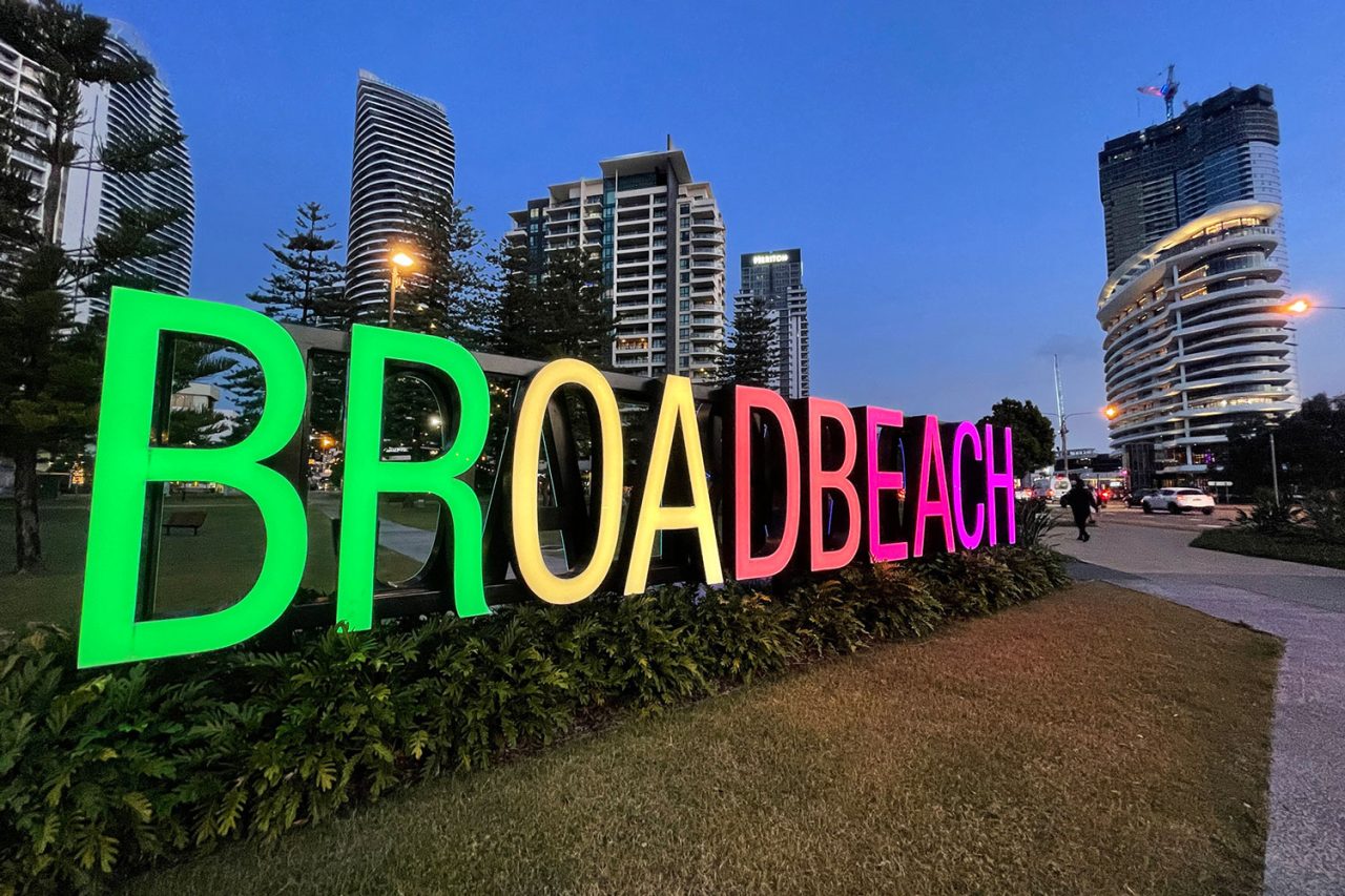 Side view of the illuminated rainbow-coloured Broadbeach sign.