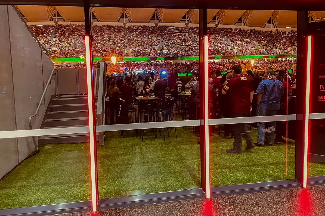 Red light tubes on poles at the entrance to an event marquee.