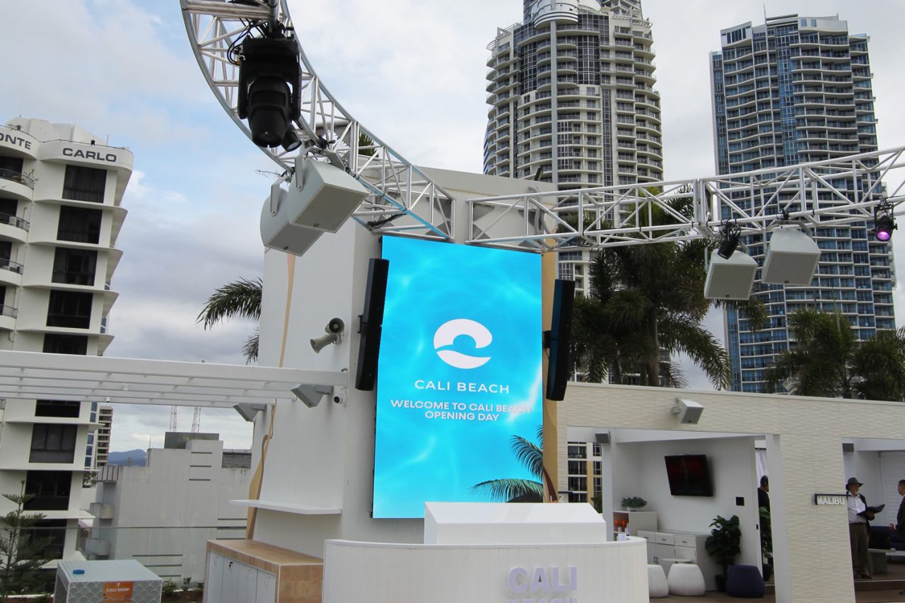 Vertical outdoor screen beneath a lighting truss at Cali Beach.
