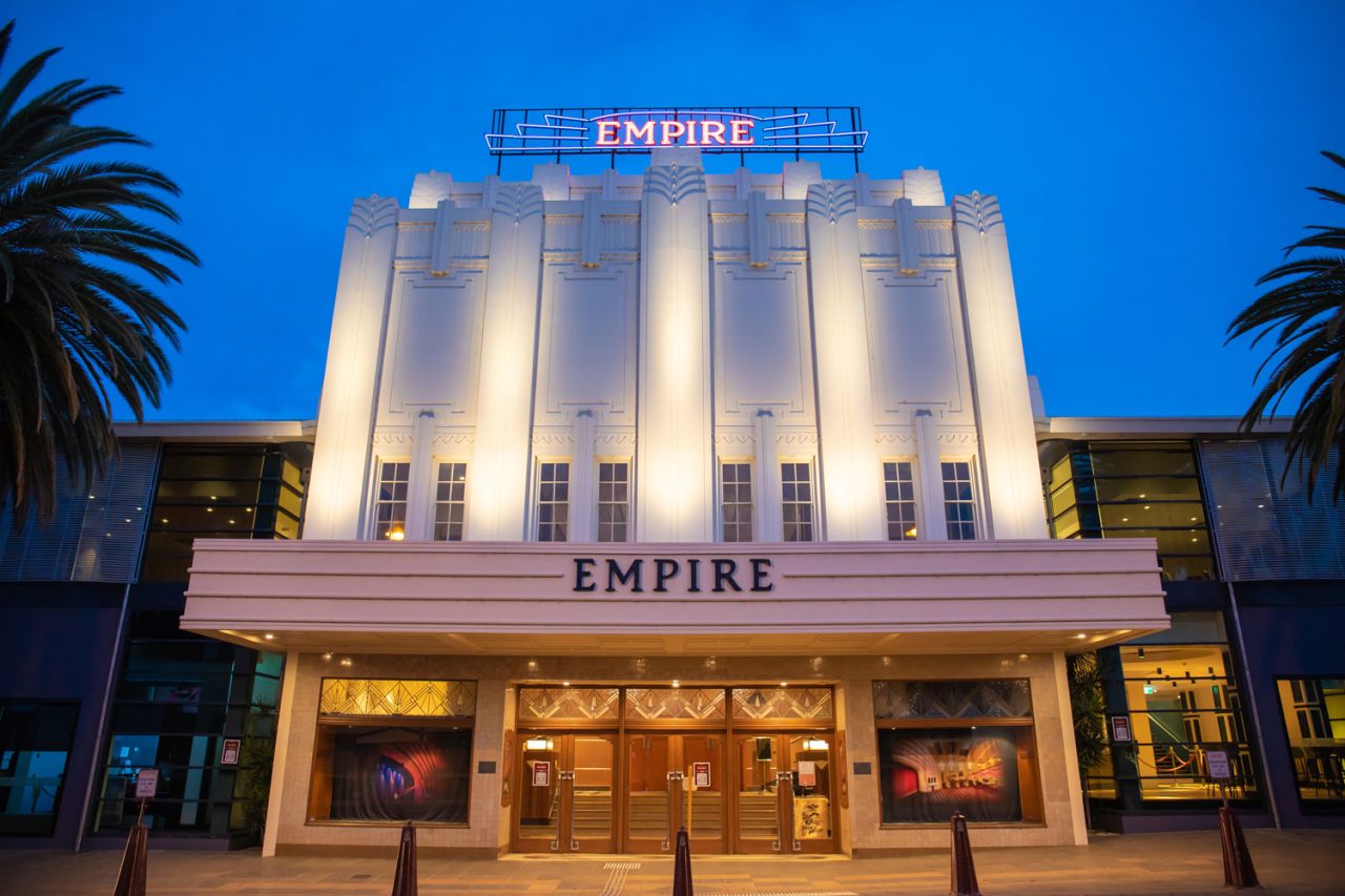 Warm white lighting on the Empire Theatre facade against a blue evening sky.
