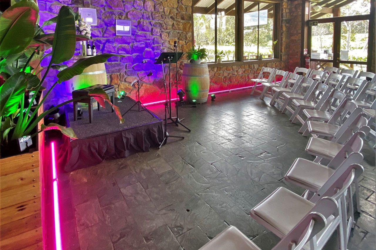 Pink and green light tubes around empty chairs and instruments at Cullen Wines.