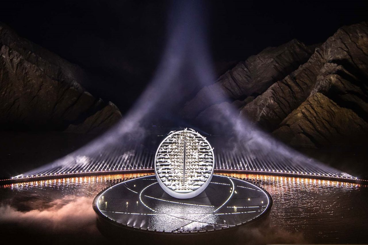 White beams frame a circular illuminated sculpture at the UAE National Day celebration.
