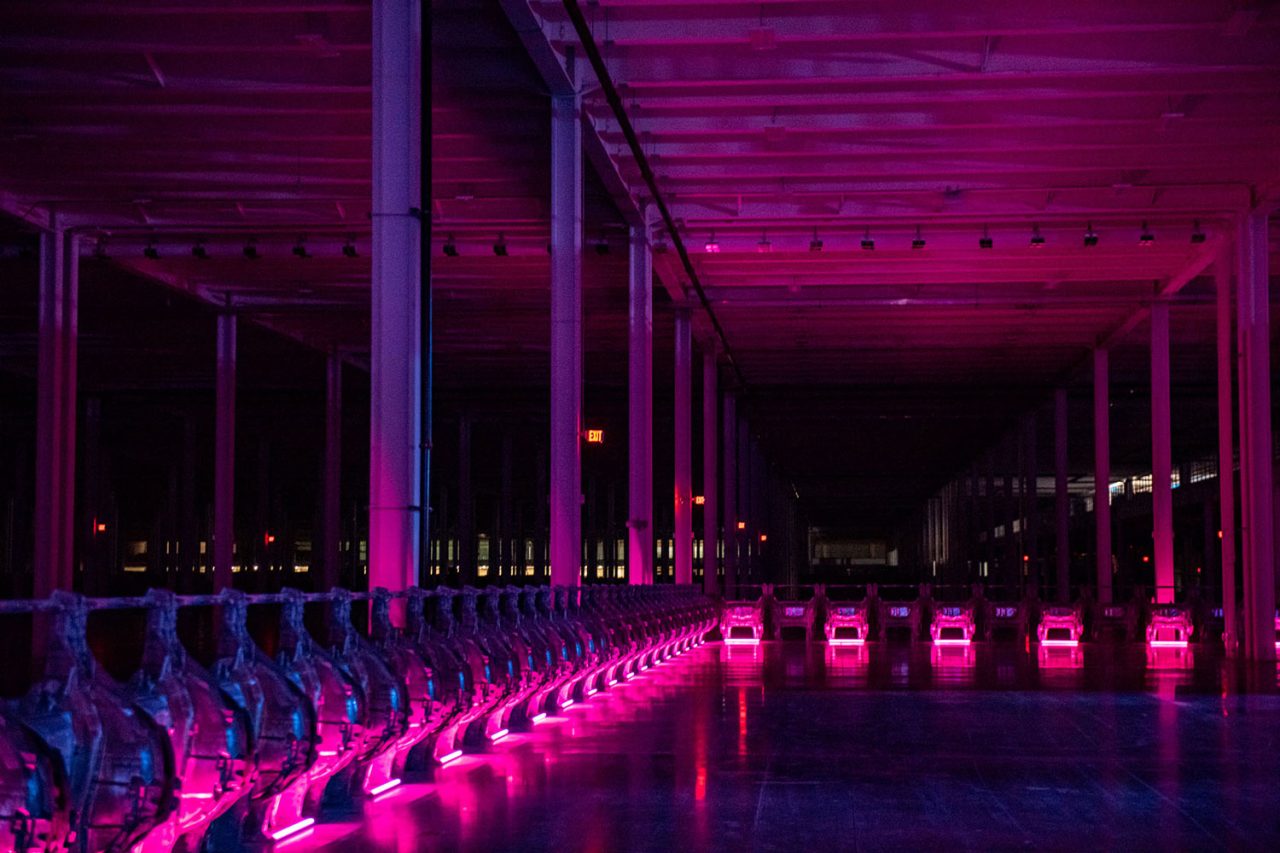 Pink lights line industrial equipment at Tesla's Cyber Rodeo.