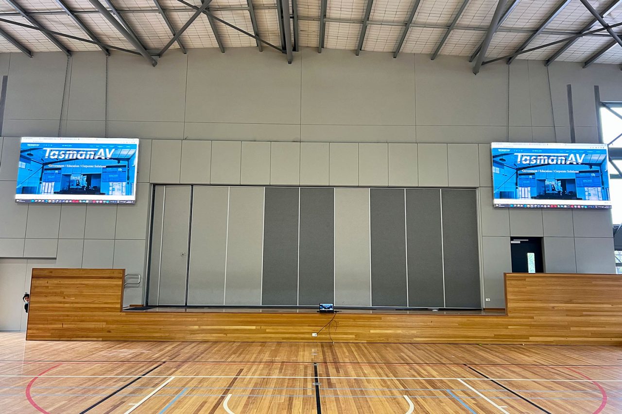 Two LED screens on either side of the Tarneit Rise Primary School auditorium.