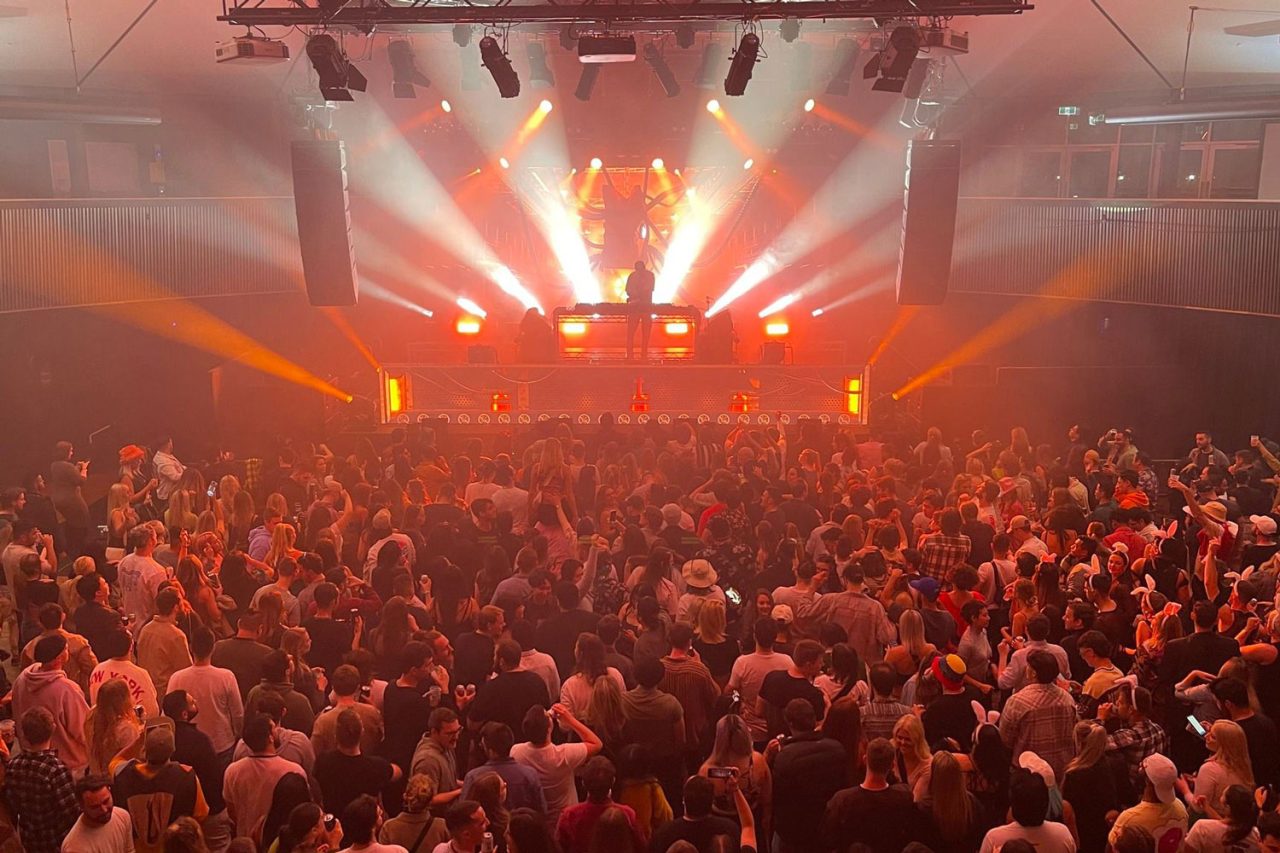 Orange and white beams above the crowded Roundhouse at the Dillon Francis and Benson show.
