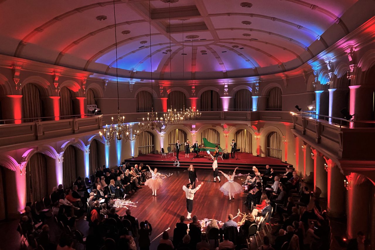 Red and blue light across the ballroom ceiling during Let Us Dance in Perth.
