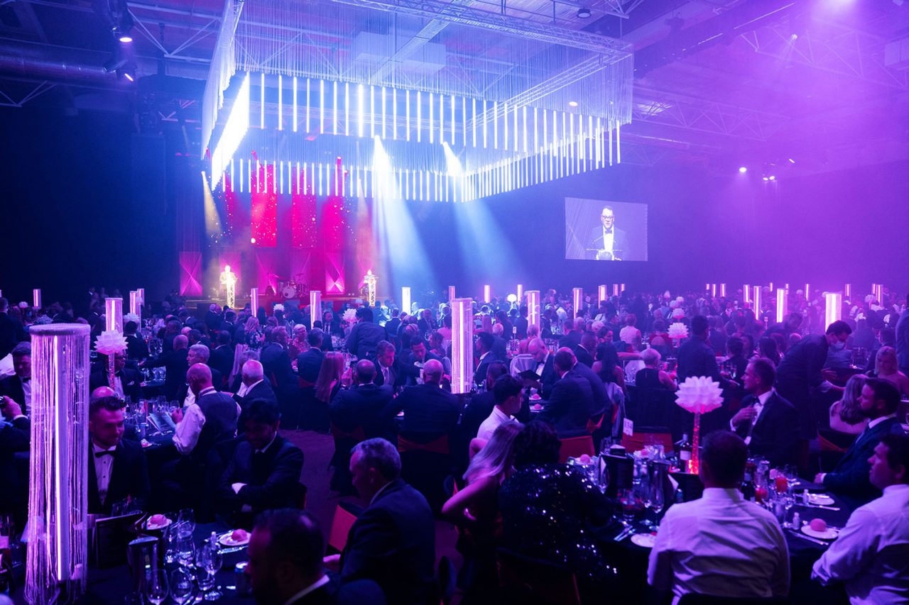 Guests at purple-lit banquet tables beneath suspended lighting at the 2022 Master Builders Australia awards.
