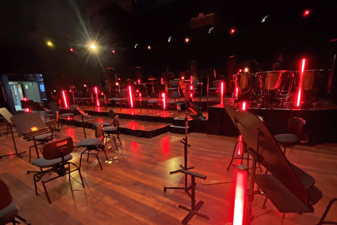 Red light tubes among empty orchestra chairs and music stands for the Drapht and WASO recording.