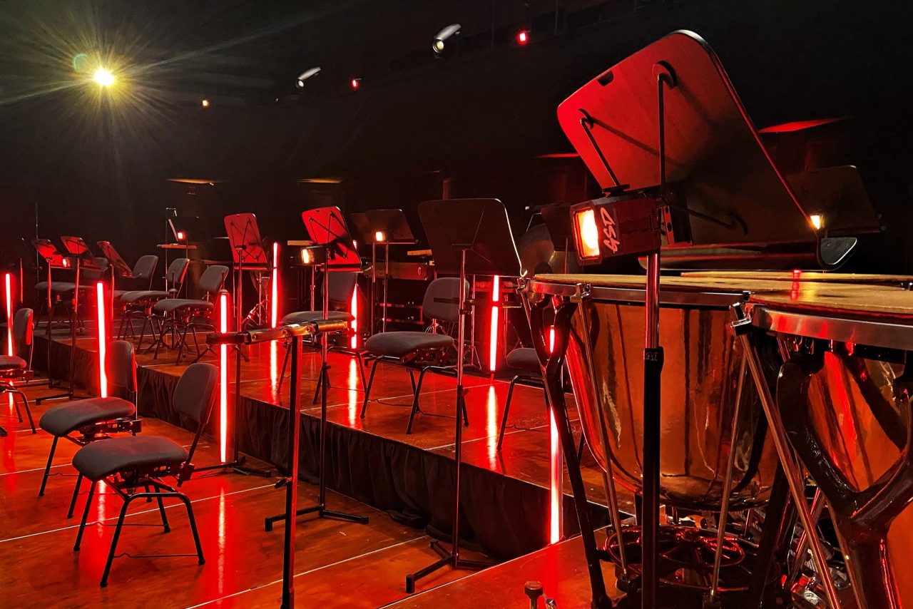 Red light tubes between music stands on the set for Drapht and the West Australian Symphony Orchestra.
