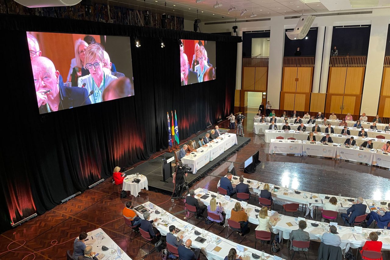 Side view of delegates, stage and paired screens in the Jobs and Skills Summit hall.