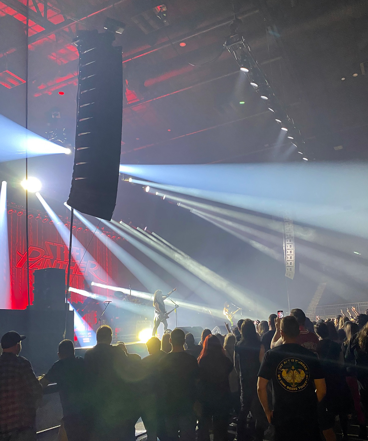 White beams from the stage over the audience at a Steel Panther show.