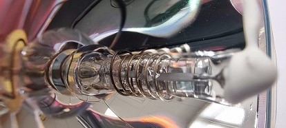 Close-up of a discharge lamp inside a reflector.