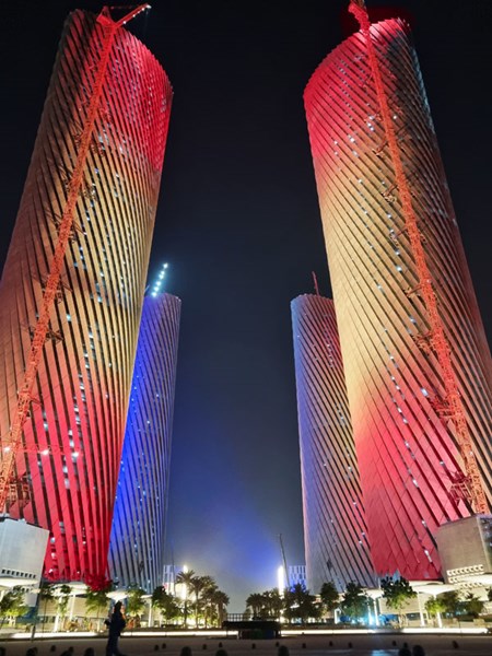 Red illumination along the Lusail Plaza Towers against the night sky.
