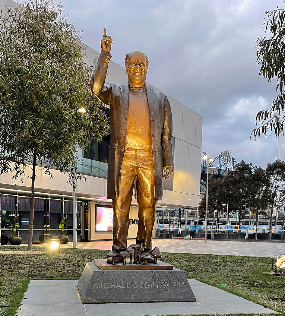 Warm lighting on the bronze Michael Gudinski memorial outside Rod Laver Arena.