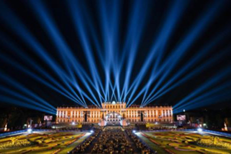 Blue beams fan above Schonbrunn Castle and its gardens during a concert.
