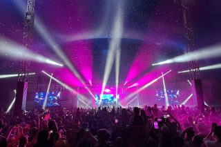 Pink lighting and crossing white beams above the Spilt Milk crowd.