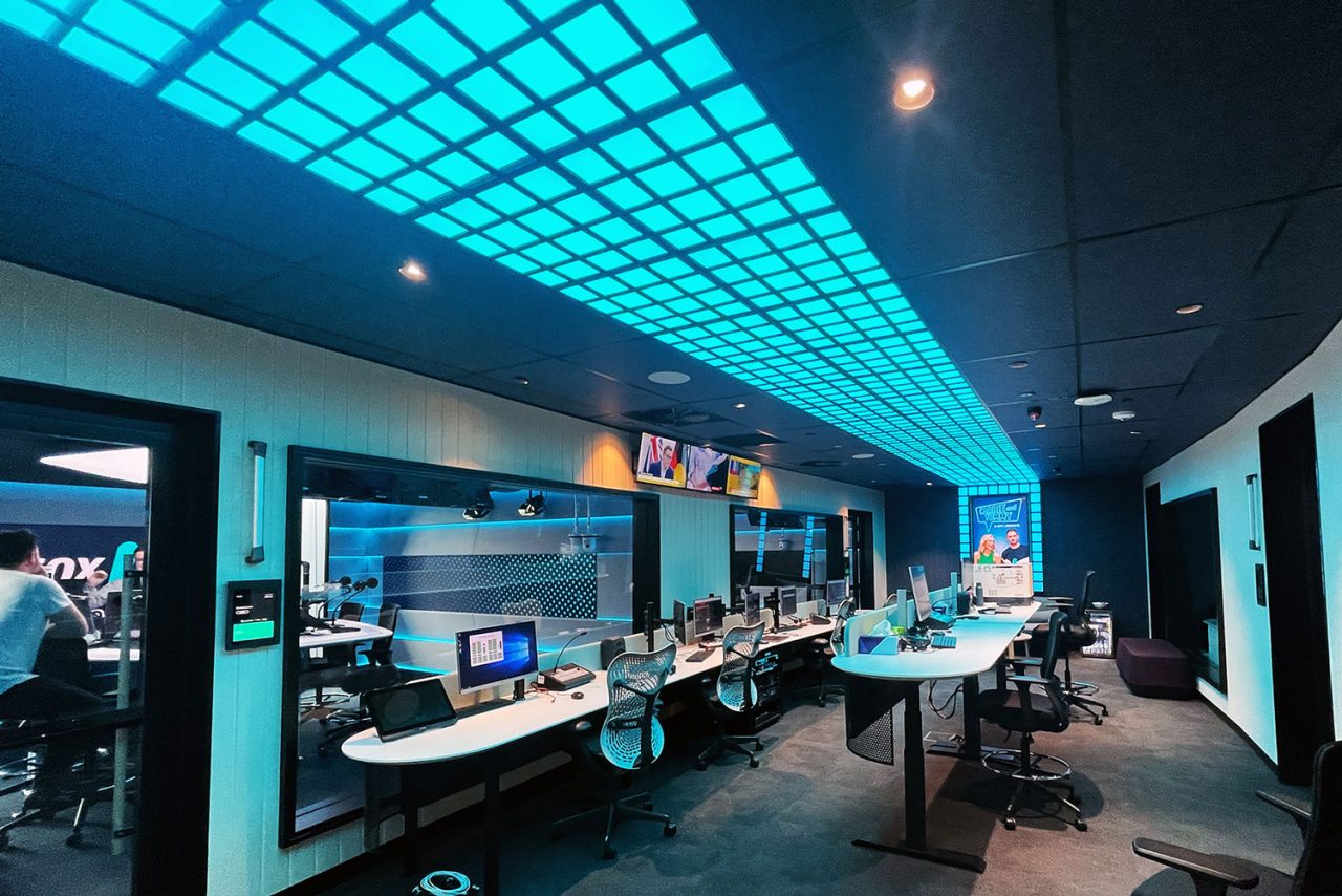Cyan illuminated ceiling panels along a corridor of Southern Cross Austereo studios.