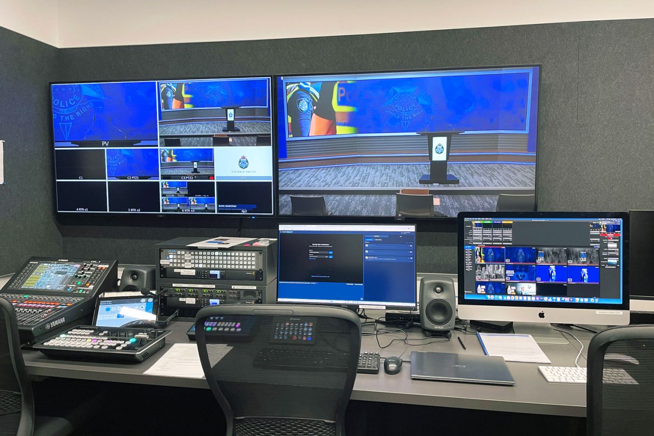 Production monitors and control consoles in the Victoria Police media centre control room.